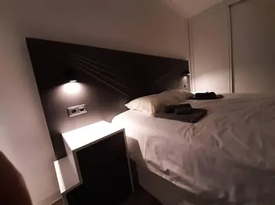 a bedroom with a large bed with a black headboard at Santo António Guest Apartment in Funchal