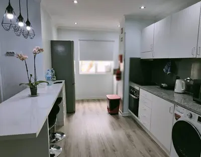 a kitchen with white cabinets and a counter top at Santo António Guest Apartment in Funchal