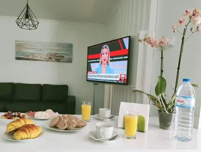 a table topped with plates of food and a tv at Santo António Guest Apartment in Funchal