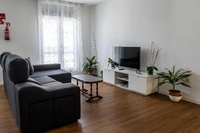 a living room with a couch and a television at City Heart Funchal in Funchal