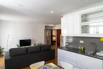 a living room with a couch and a kitchen at City Heart Funchal in Funchal