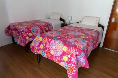 two beds in a room with pink comforter at City Heart Funchal in Funchal