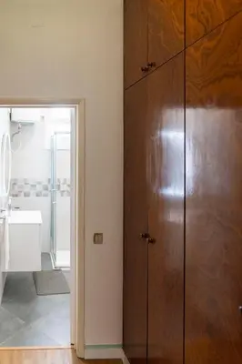 a bathroom with a large wooden cabinet next to a sink at City Heart Funchal in Funchal