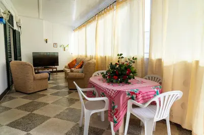 a living room with a table and chairs and a television at City Heart Funchal in Funchal