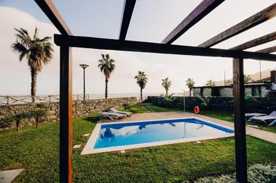 a swimming pool in the yard of a house with palm trees at Casas do Calhau Miúdo - Seixal in Seixal