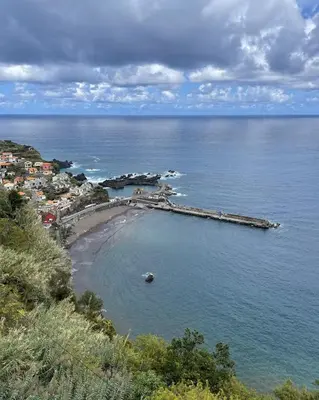 a beach with a pier in the middle of the water at Casas do Calhau Miúdo - Seixal in Seixal