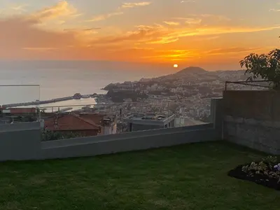a view of the sunset from a house at Myrtus - House with sea view and garden in Funchal