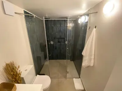 a bathroom with a glass shower with a toilet at Myrtus - House with sea view and garden in Funchal