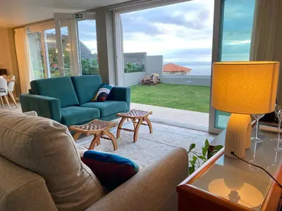 a living room with a couch and chairs and a large window at Myrtus - House with sea view and garden in Funchal