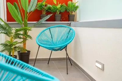 a blue chair sitting in a room with plants at Os Fragosinhos II by Amazing Madeira in Funchal