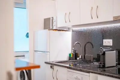a kitchen with white cabinets and a sink at Os Fragosinhos II by Amazing Madeira in Funchal