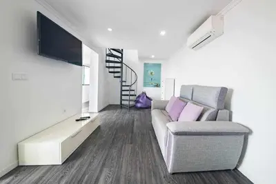 a living room with a couch and a flat screen tv at Lombo do Doutor Cottage 1 by Mth in Calheta