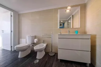 a bathroom with a toilet and a sink and a mirror at Lombo do Doutor Cottage 1 by Mth in Calheta