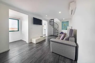 a living room with a couch and a stair case at Lombo do Doutor Cottage 1 by Mth in Calheta