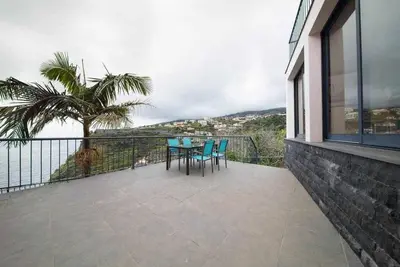 a patio with a table and chairs on a balcony at Lombo do Doutor Cottage 2 by Mth in Calheta