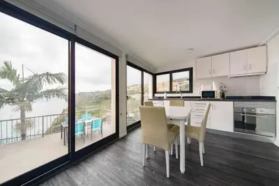 a kitchen and dining room with a table and chairs at Lombo do Doutor Cottage 2 by Mth in Calheta