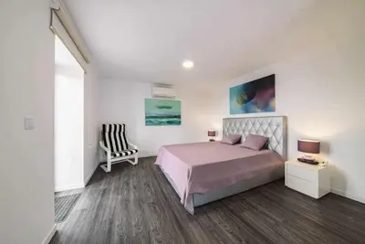 a bedroom with a bed and a chair at Lombo do Doutor Cottage 2 by Mth in Calheta