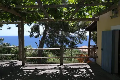 a view of the ocean from the porch of a house at Chalet Tropical in Arco da Calheta