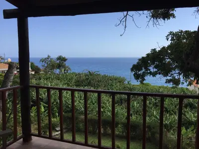 a view of the ocean from the balcony of a house at Chalet Tropical in Arco da Calheta