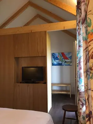 a bedroom with a bed and a tv in a room at Chalet Tropical in Arco da Calheta