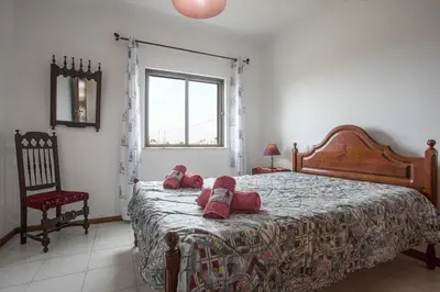a bedroom with a bed with two stuffed animals on it at Villa Bartoni in Aljezur