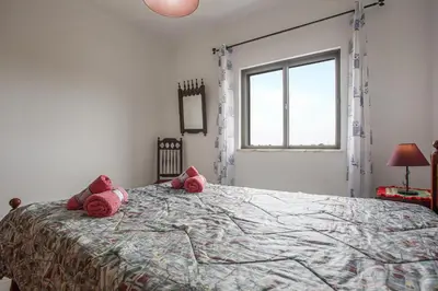 a bedroom with a large bed with pink stuffed animals on it at Villa Bartoni in Aljezur