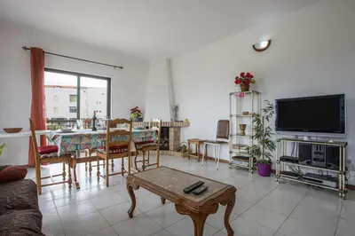 a living room with a tv and a table at Villa Bartoni in Aljezur