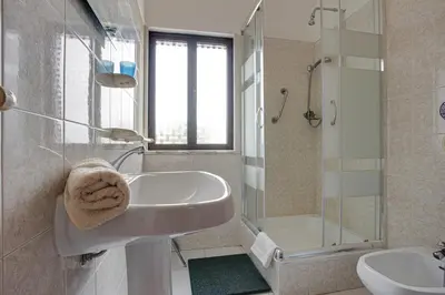 a white bathroom with a sink and a shower at Villa Bartoni in Aljezur