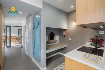 a kitchen with a fireplace in the middle of it at Calheta beautiful character cottage Villa Loreto in Arco da Calheta