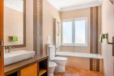a bathroom with a sink and a toilet and a tub at Moradia com piscina e vista Mar in Aljezur