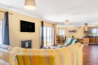 a living room with a couch and a tv at Moradia com piscina e vista Mar in Aljezur