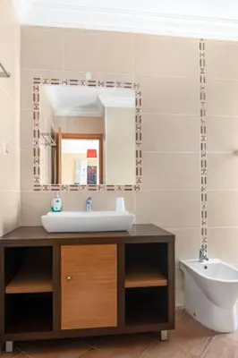 a bathroom with a sink and a mirror and a toilet at Moradia com piscina e vista Mar in Aljezur