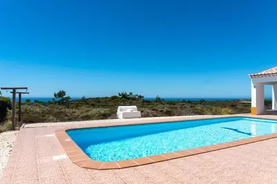 a swimming pool in front of a house at Moradia com piscina e vista Mar in Aljezur