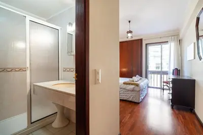 a bathroom with a tub and a sink and a bedroom at GuestReady - Varanda de belas lembranças in Funchal