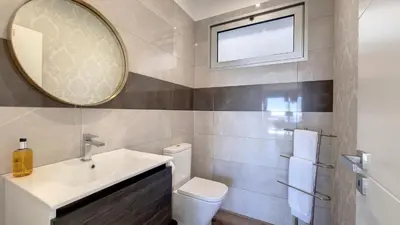 a bathroom with a sink and a mirror and a toilet at 24, The Townhouse by LovelyStay in Funchal