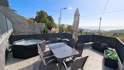 a patio with a table and chairs and a hot tub at 24, The Townhouse by LovelyStay in Funchal