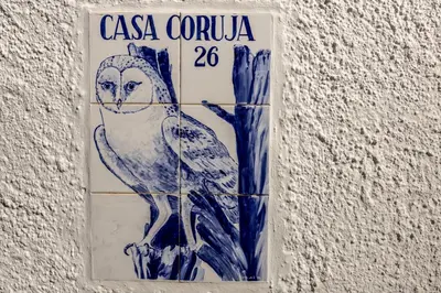 a sign on the side of a building with an owl at Casa Coruja in Luz