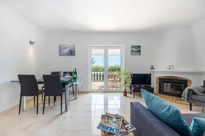 a living room with a table and a fireplace at Casa Coruja in Luz