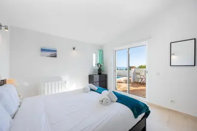 a bedroom with a bed and a view of the ocean at Casa Coruja in Luz
