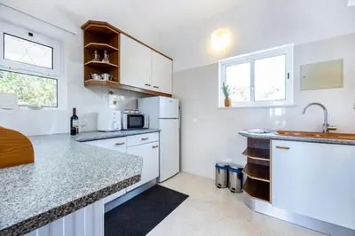 a kitchen with white cabinets and a counter top at Casa Coruja in Luz