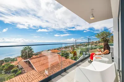 a woman sitting on a balcony with a view of the ocean at Casa Jose Antonio A by Homie in Gaula