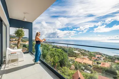 a woman standing on a balcony looking out at the ocean at Casa Jose Antonio B by Homie in Gaula