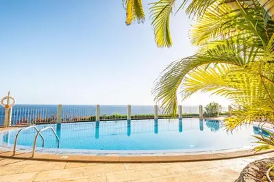 a swimming pool with the ocean in the background at SUPER Cliff in Funchal