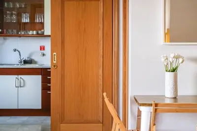 a kitchen with a wooden door and a table with flowers at SUPER Cliff in Funchal