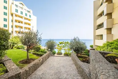 a walkway in front of a building and the ocean at SUPER Cliff in Funchal