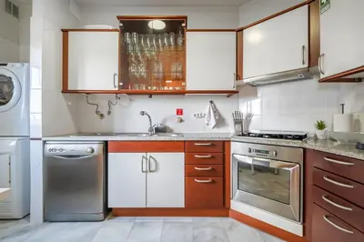 a kitchen with white cabinets and stainless steel appliances at SUPER Cliff in Funchal