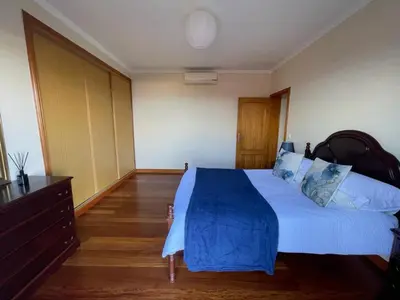 a bedroom with a large bed with a blue blanket at Wanderlust House in Ponta Delgada