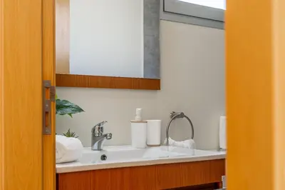 a bathroom with a sink and a mirror at Villa Angela- Madeira Inn Group in Calheta