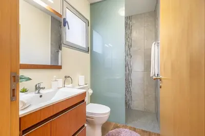 a bathroom with a toilet and a sink and a shower at Villa Angela- Madeira Inn Group in Calheta