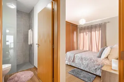 a bedroom with a bed and a bathroom with a shower at Villa Angela- Madeira Inn Group in Calheta